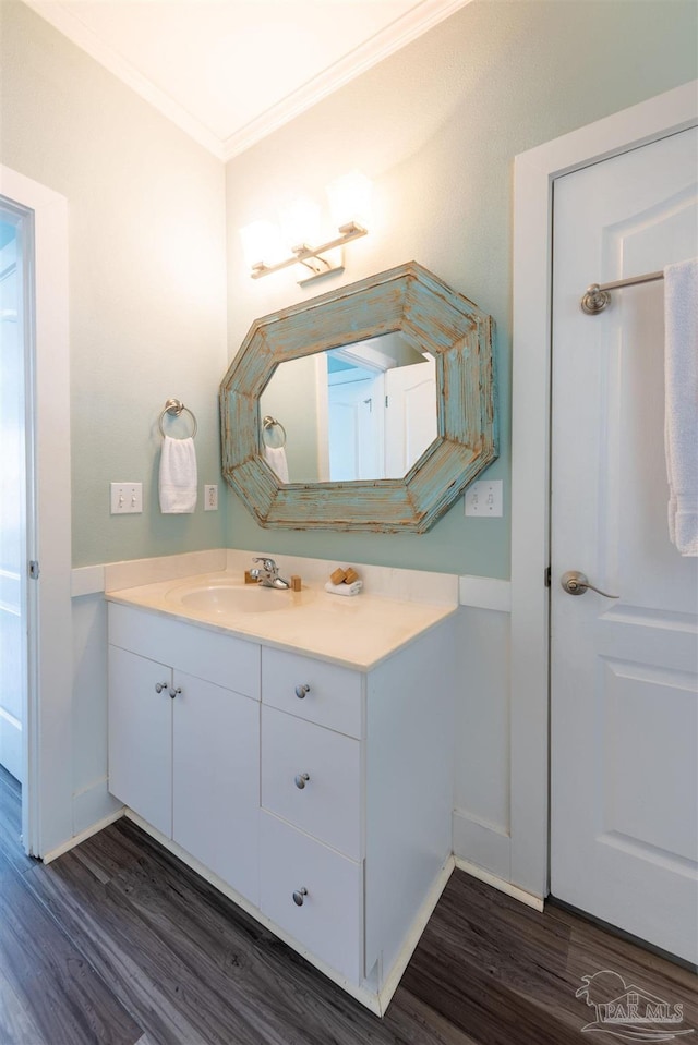 bathroom with crown molding, vanity, and hardwood / wood-style flooring