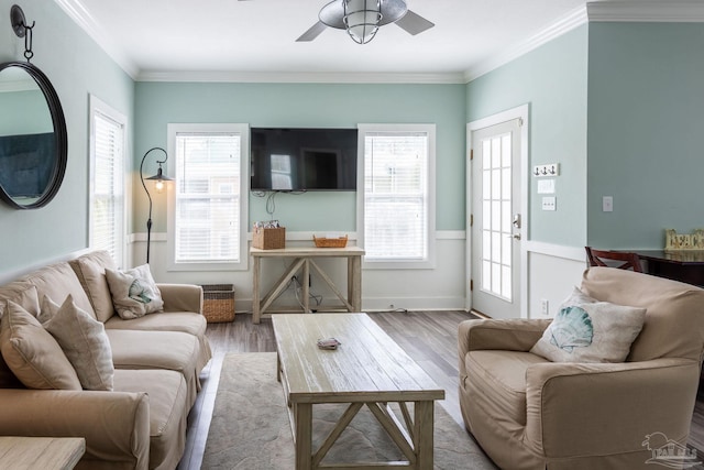 living room featuring light hardwood / wood-style flooring, ornamental molding, ceiling fan, and a wealth of natural light