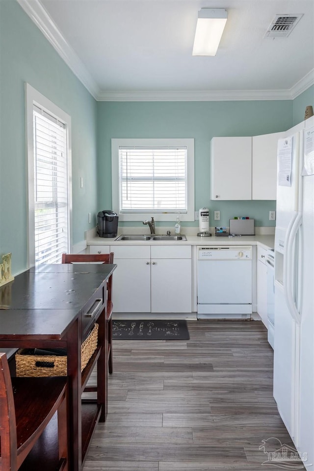 kitchen with a healthy amount of sunlight, white appliances, white cabinetry, and sink