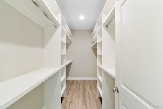 walk in closet with light hardwood / wood-style flooring