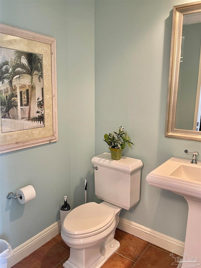 bathroom with sink, toilet, and tile patterned flooring