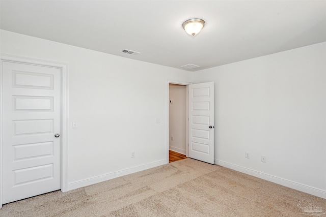 spare room featuring light colored carpet