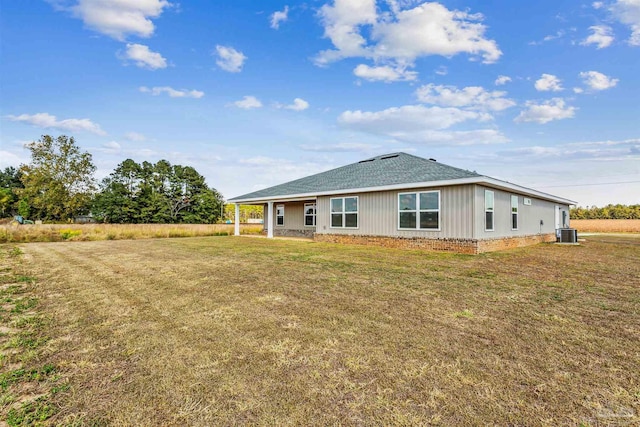 back of property featuring cooling unit and a lawn