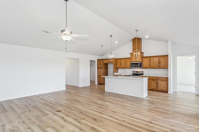 kitchen featuring high vaulted ceiling, an island with sink, ceiling fan, light hardwood / wood-style floors, and stainless steel appliances