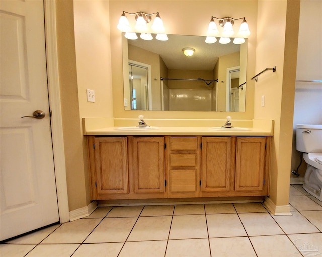 bathroom featuring vanity, a shower, tile patterned floors, and toilet