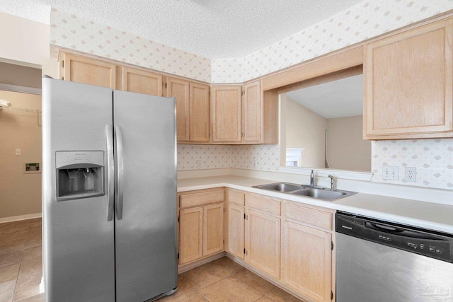 kitchen with stainless steel appliances, light tile patterned flooring, sink, and light brown cabinets