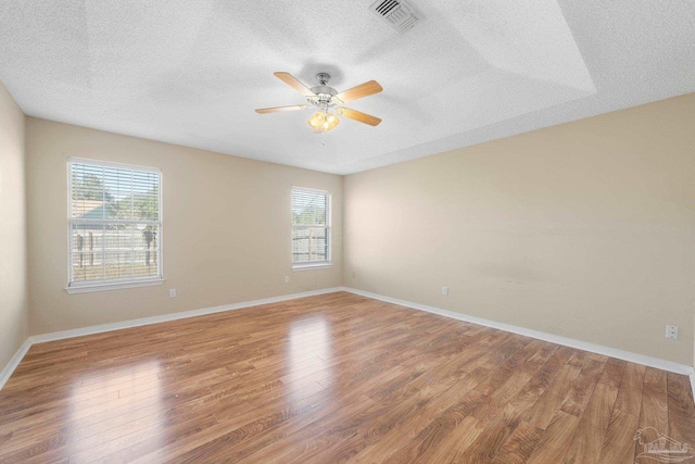 spare room with ceiling fan, plenty of natural light, and hardwood / wood-style floors