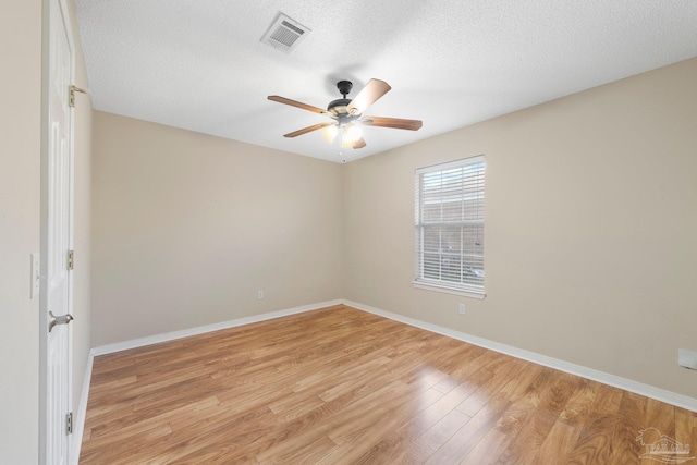 empty room featuring ceiling fan, light hardwood / wood-style flooring, and a textured ceiling