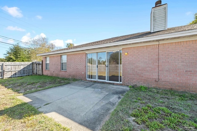 back of property featuring a yard and a patio area