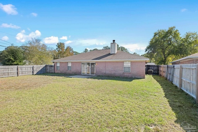 back of house featuring a yard and central AC