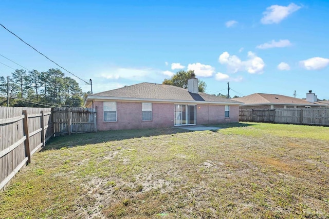 rear view of property with a yard