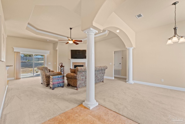 living room featuring decorative columns, ceiling fan, and light colored carpet