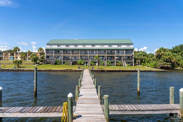 view of dock with a yard and a water view