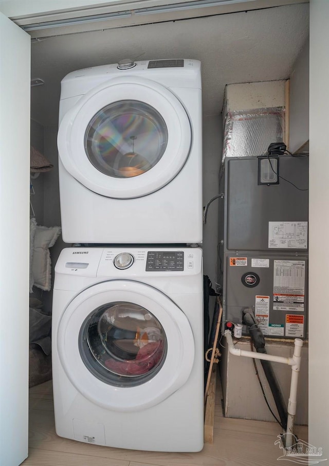 clothes washing area featuring stacked washer / dryer