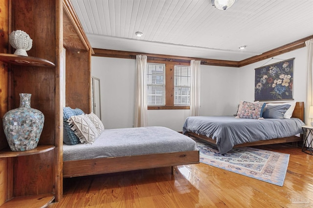 bedroom featuring wood ceiling, crown molding, and wood finished floors