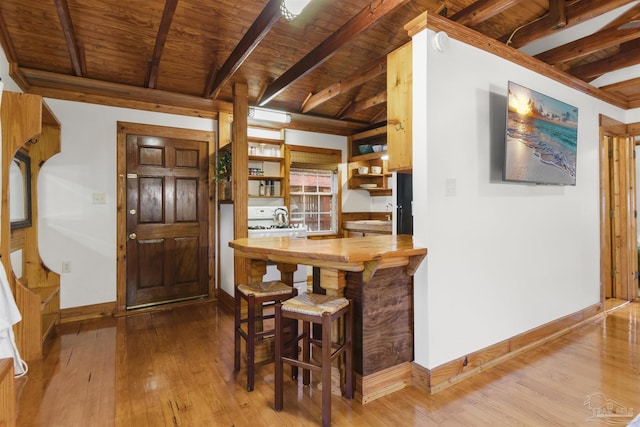 dining area featuring light wood-type flooring, wooden ceiling, baseboards, and beam ceiling