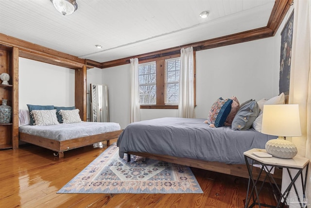 bedroom featuring ornamental molding and wood-type flooring