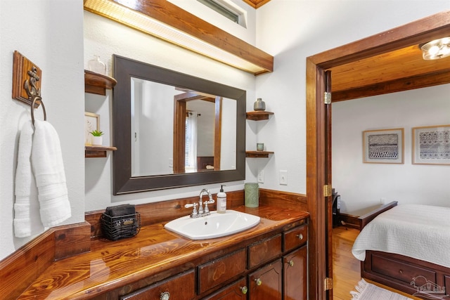 ensuite bathroom with wood finished floors, vanity, and ensuite bathroom