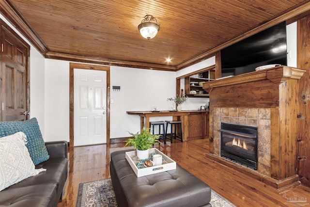 living area featuring wooden ceiling, crown molding, and wood finished floors