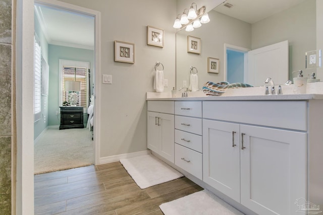 14273 Beach Heather Ct, Pensacola, FL 32507 - bathroom featuring crown molding, baseboards, double vanity, wood finished floors, and ensuite bath