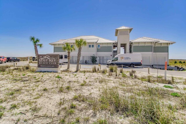 14273 Beach Heather Ct, Pensacola, FL 32507 - back of house featuring a standing seam roof, driveway, and metal roof