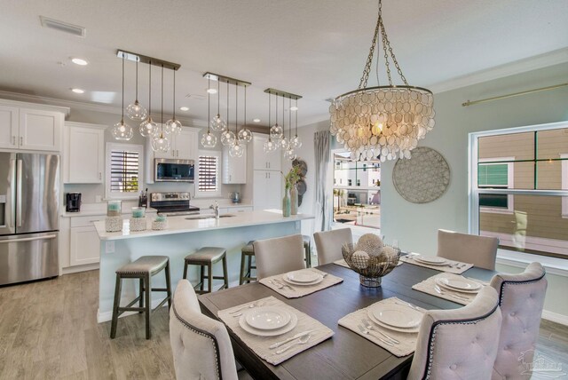 14273 Beach Heather Ct, Pensacola, FL 32507 - dining space featuring visible vents, crown molding, recessed lighting, light wood-style floors, and a notable chandelier