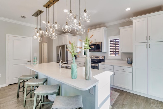 14273 Beach Heather Ct, Pensacola, FL 32507 - kitchen featuring crown molding, an island with sink, white cabinets, stainless steel appliances, and a sink