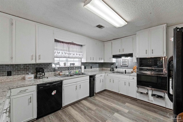 kitchen featuring black appliances, sink, light wood-type flooring, backsplash, and white cabinetry