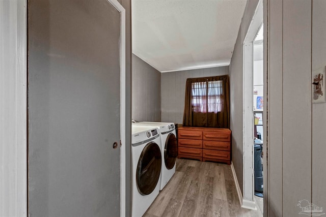 laundry area with light hardwood / wood-style flooring and washing machine and dryer