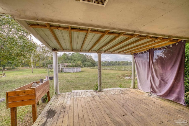 wooden deck featuring a lawn