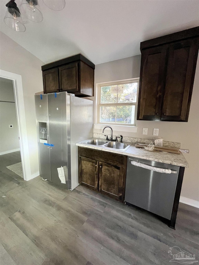 kitchen featuring sink, dark brown cabinetry, stainless steel appliances, and light hardwood / wood-style flooring