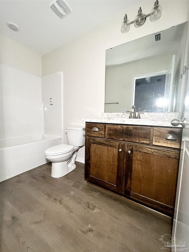 full bathroom featuring bathing tub / shower combination, vanity, wood-type flooring, and toilet