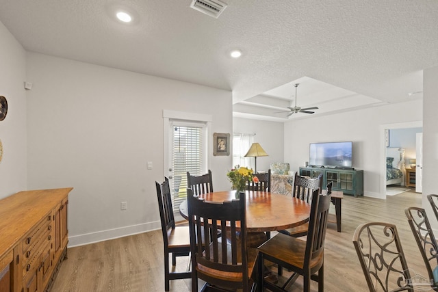 dining room with ceiling fan, a textured ceiling, and light hardwood / wood-style floors