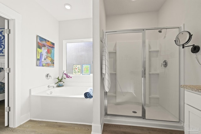 bathroom featuring hardwood / wood-style flooring, vanity, and independent shower and bath