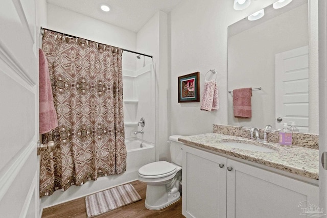 full bathroom featuring shower / tub combo with curtain, hardwood / wood-style floors, vanity, and toilet