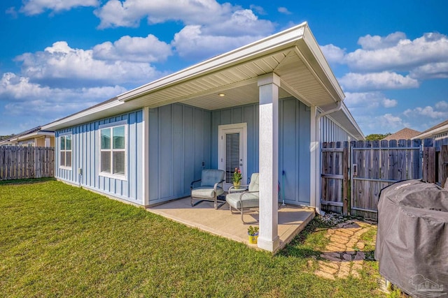 back of property featuring a patio area and a lawn