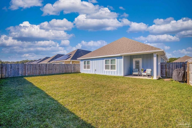 rear view of house featuring a patio area and a lawn