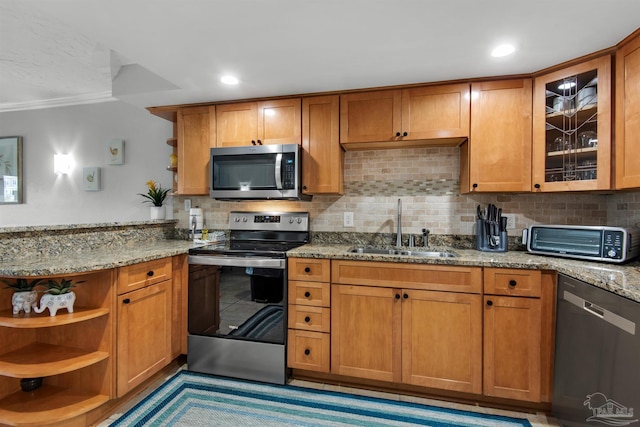 kitchen with stainless steel appliances, backsplash, light stone countertops, ornamental molding, and sink