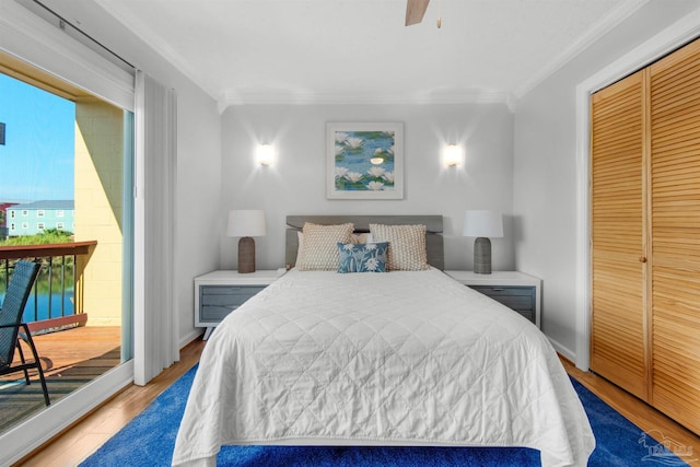 bedroom featuring ceiling fan, light hardwood / wood-style floors, crown molding, multiple windows, and a closet