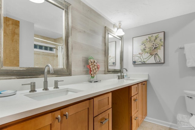 bathroom with toilet, vanity, and tile patterned flooring