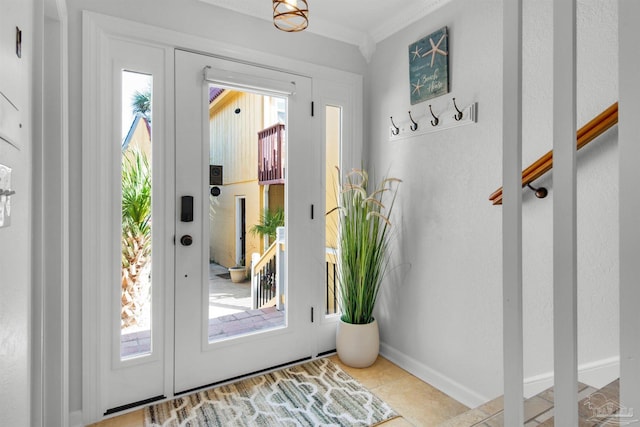 entryway with light tile patterned floors and crown molding