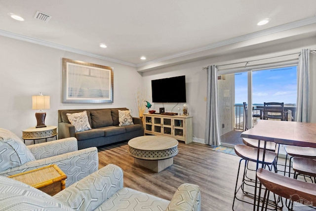 living area with visible vents, crown molding, baseboards, recessed lighting, and wood finished floors
