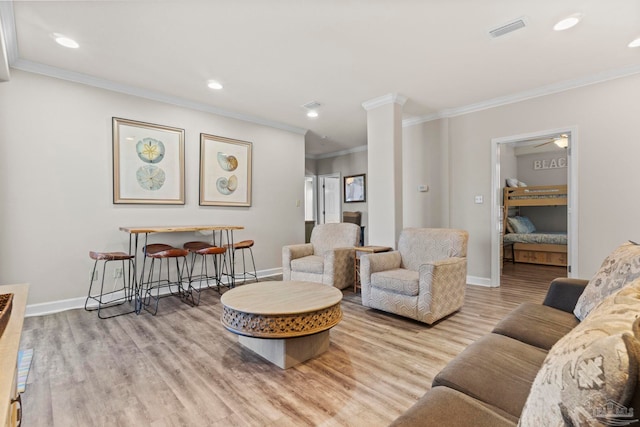 living room featuring visible vents, baseboards, wood finished floors, and a ceiling fan