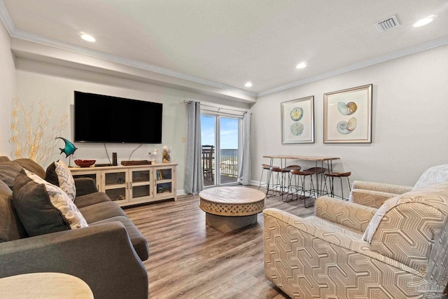 living room featuring recessed lighting, ornamental molding, baseboards, and wood finished floors