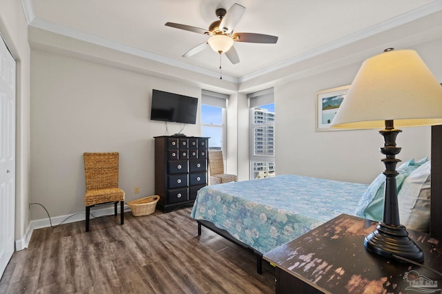 bedroom with baseboards, wood finished floors, a ceiling fan, and ornamental molding