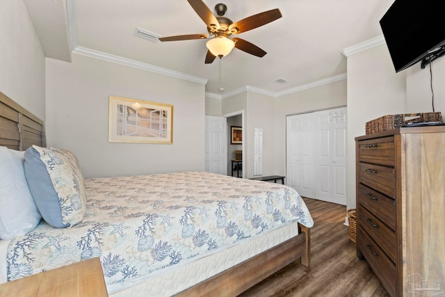 bedroom featuring visible vents, a closet, dark wood-style floors, and ornamental molding
