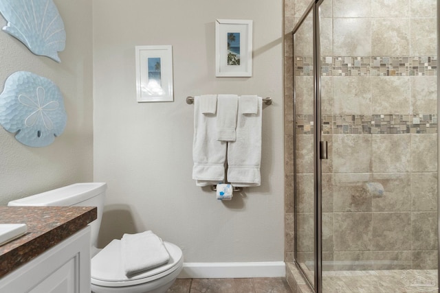 full bathroom with toilet, a shower stall, tile patterned flooring, baseboards, and vanity