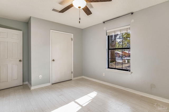 unfurnished bedroom featuring light hardwood / wood-style floors, a closet, and ceiling fan