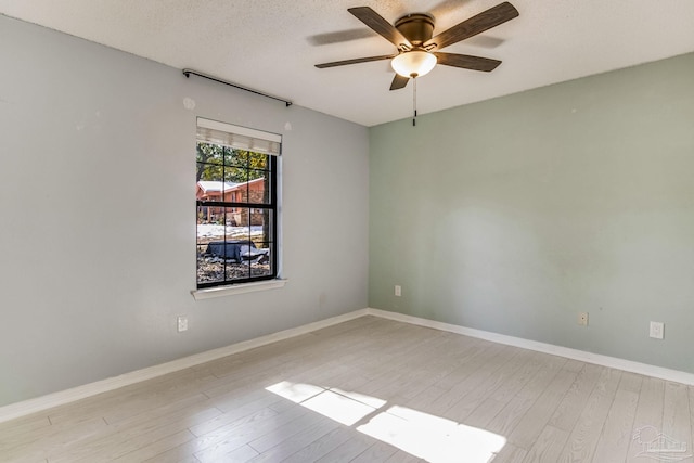 empty room featuring a textured ceiling, light hardwood / wood-style floors, and ceiling fan