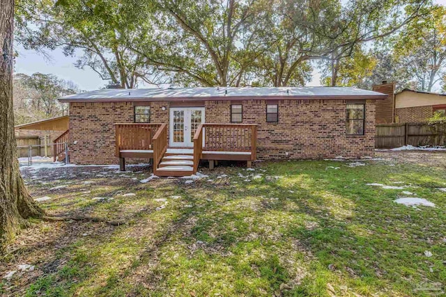 rear view of property with a deck and a lawn